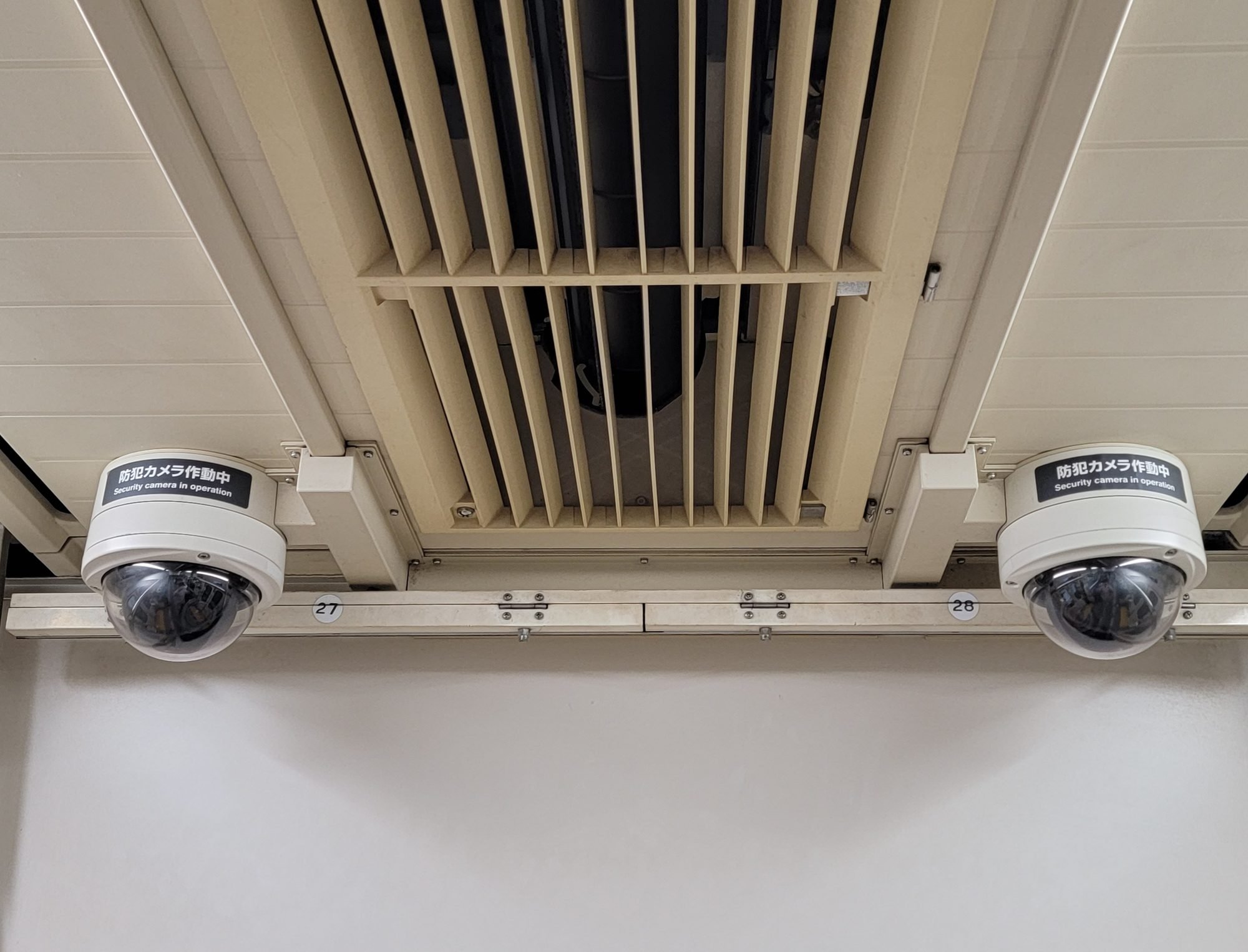 Deux caméras dôme fixées au plafond d'un bâtiment